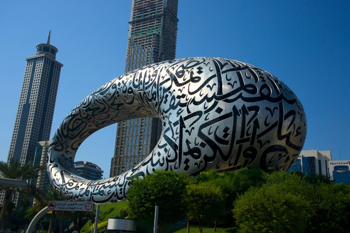 A large metal sculpture in front of a tall building